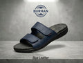 Navy blue leather slide sandal with two adjustable straps on grey stone surface